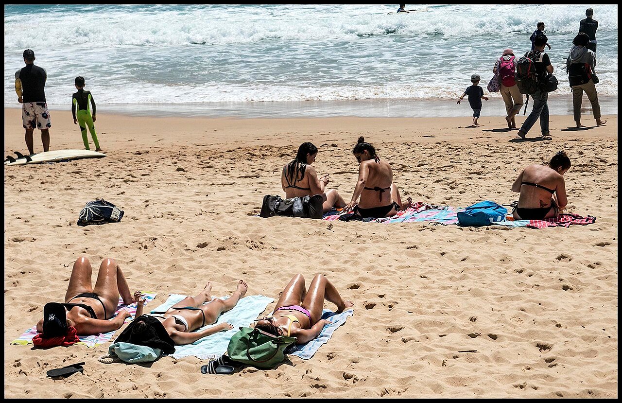Applying sunscreen lotion on a sunny beach